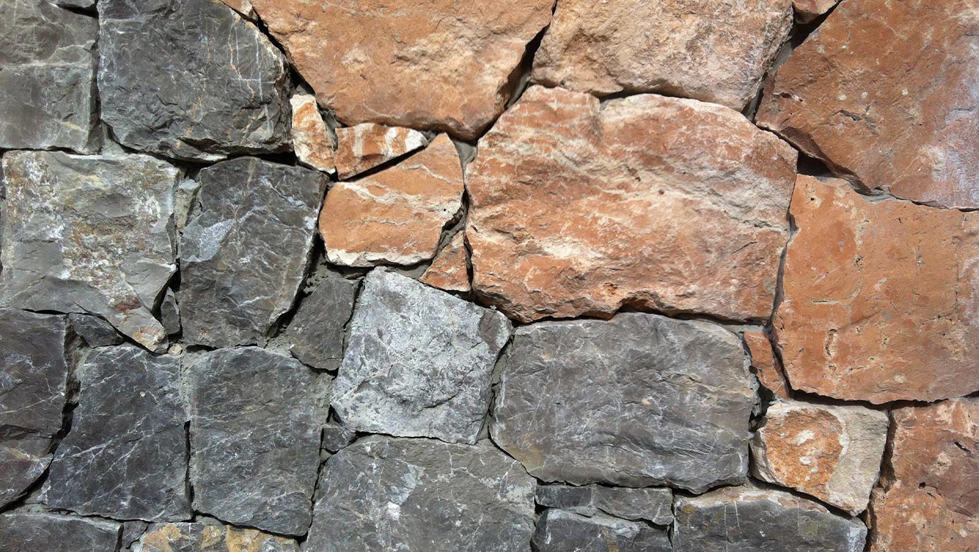 Muro de piedra roja y piedra gris. Piedra de Ibiza en Suministros Ibiza.